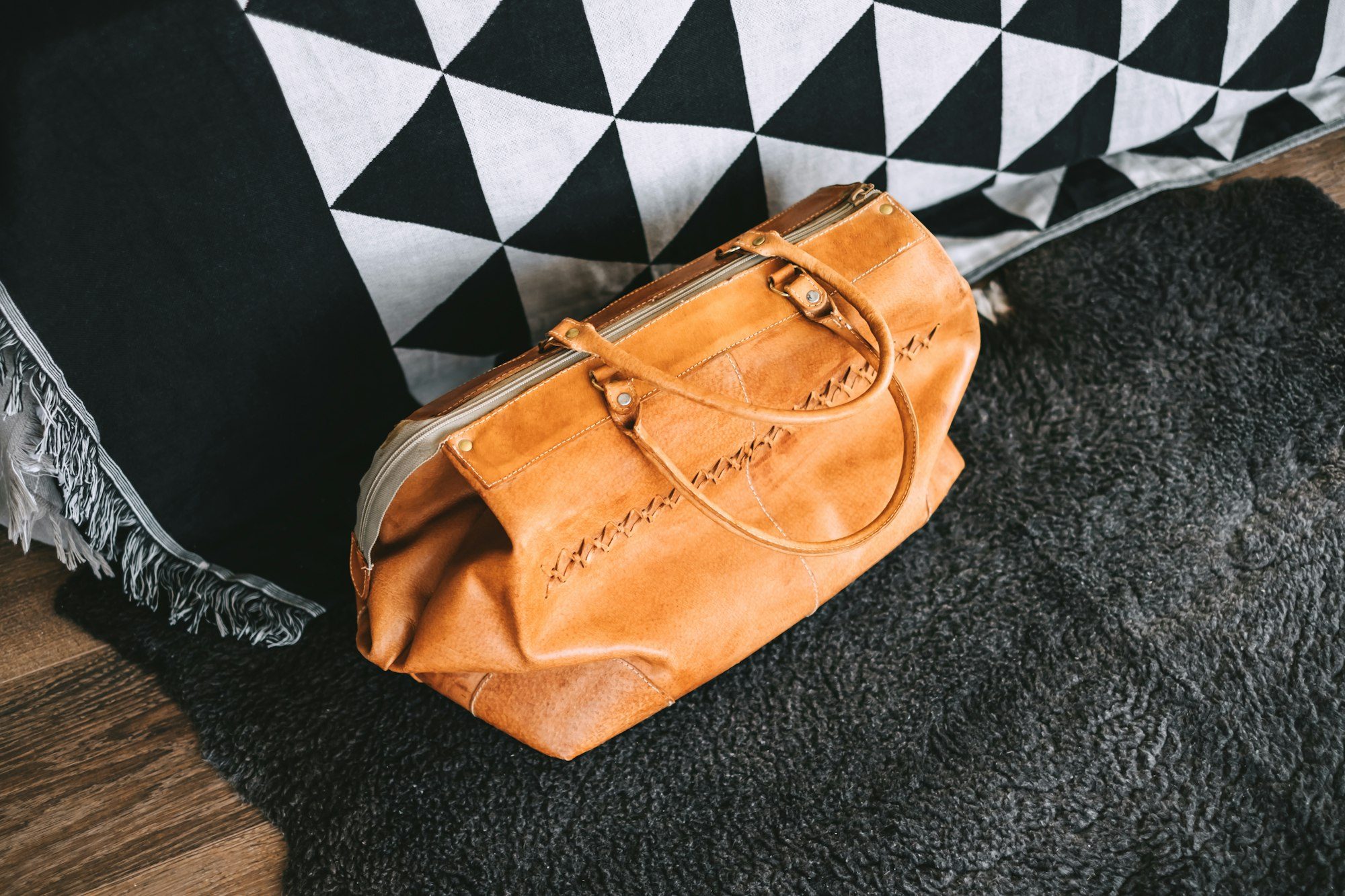 Leather travel bag near the bed in the living room. travel preparation, weekend concept.